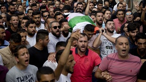 Palestinians carry the body of Aisha al-Rawbi, 47, during her funeral in the West Bank village of Biddya [File: Majdi Mohammed/AP Photo]